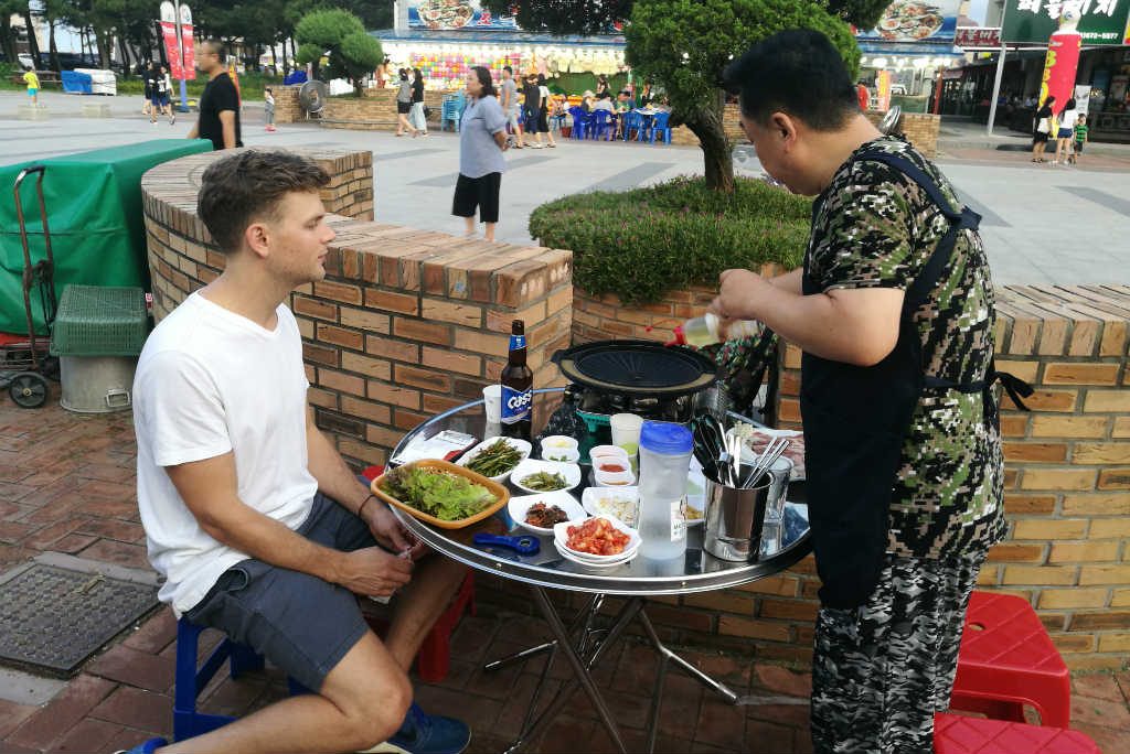 A Korean preparing our grill before eating a Korean BBQ