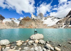 women standing in front of Mount Fitz Roy and Laguna De Los Tres in El Chalten