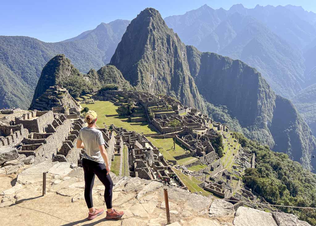 A girl standing at a photo spot overlooking the lost city of Machu Picchu