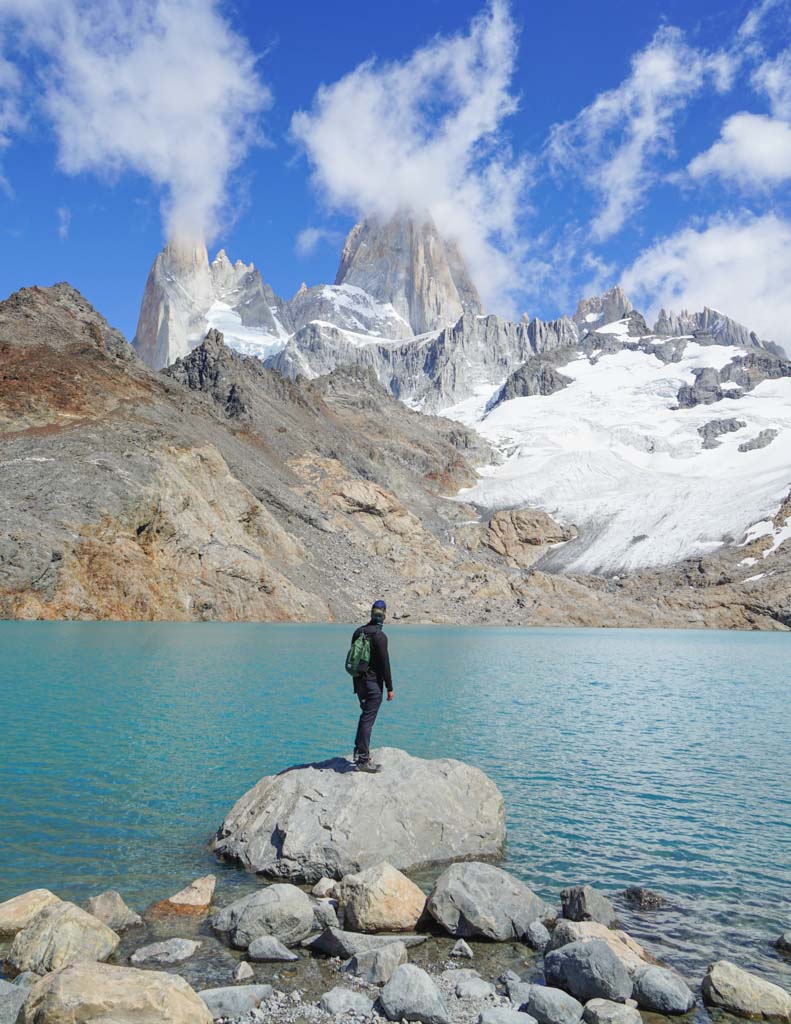 A man standing on a rock looking at Fitz Roy after completing one of the best hikes in El Chalten