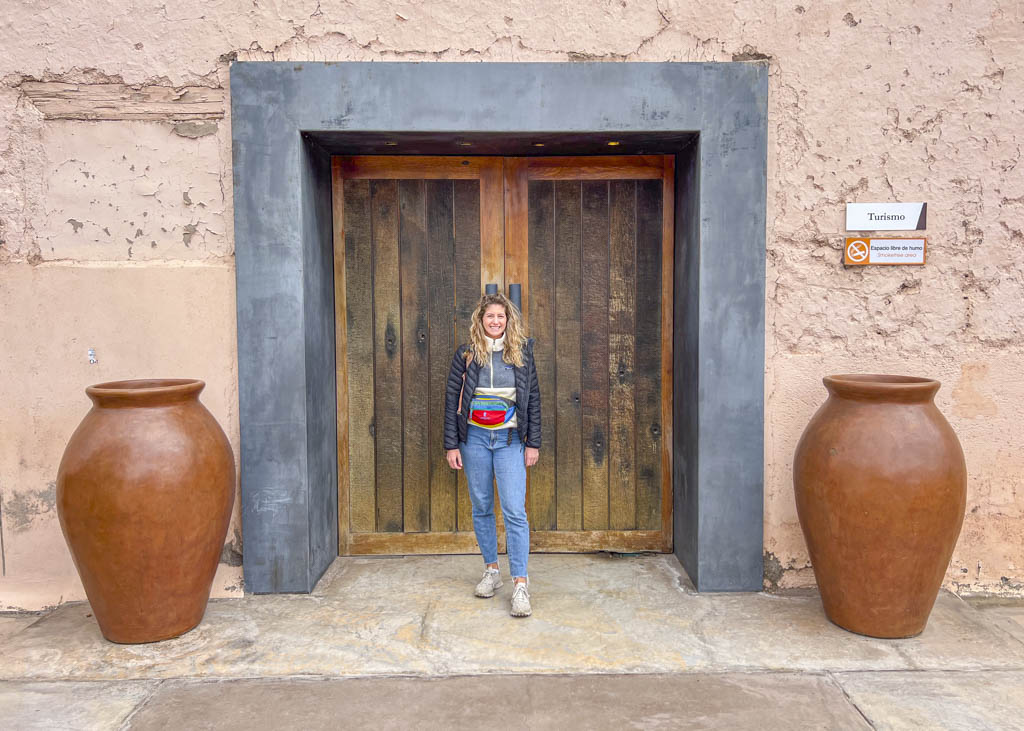 A woman standing in front of a beautiful entrance door to one of the Mendoza bodegas