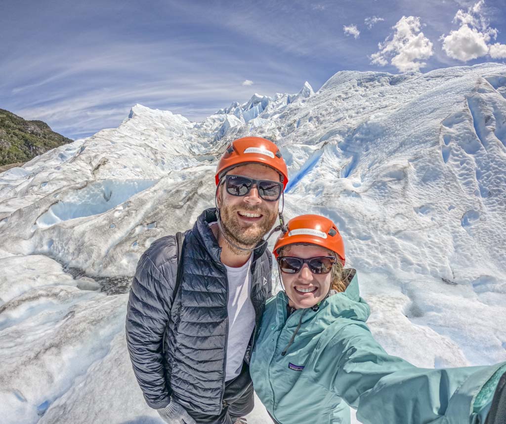 A man and woman taking a selfie while hiking on Perito Moreno Glacier in Patagonia