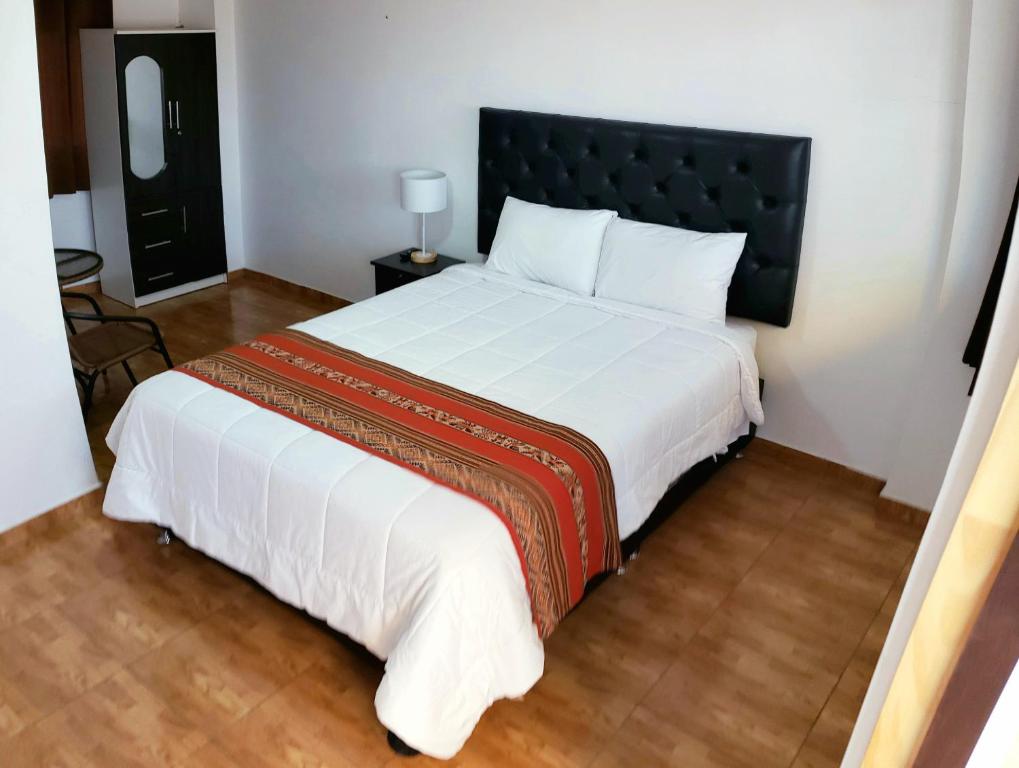 a simple hotel room with a double bed and white linen