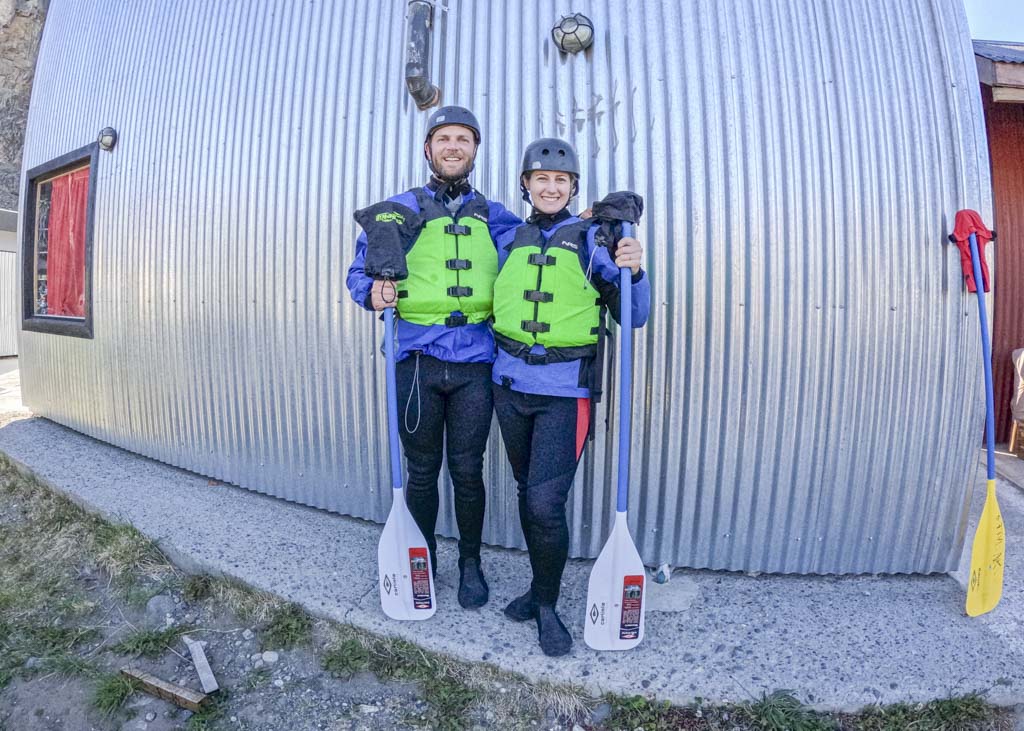 two people standing with rafting paddles in their hands